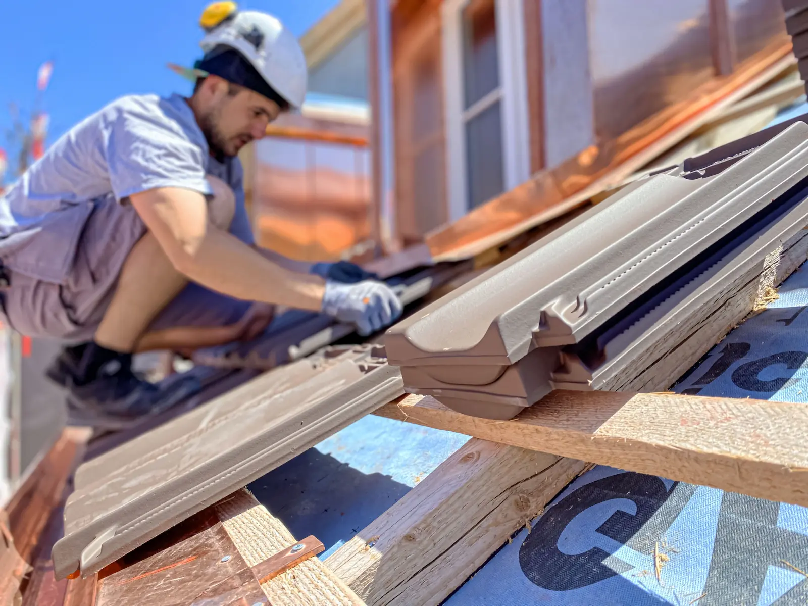 Handwerker bei Spengler- und Bedachungsarbeiten mit Ziegeln und Kupferanschlüssen