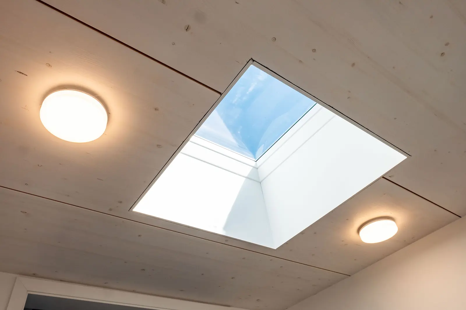 Detailansicht Dachfenster mit Blick in den Himmel.