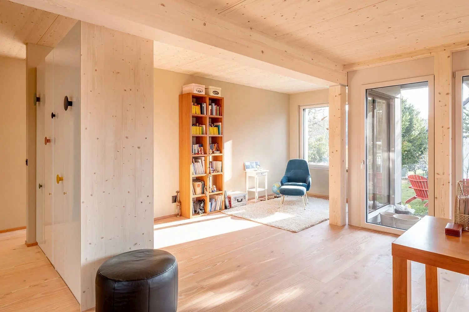 Moderner Innenausbau mit hellem Holz und großen Glasfronten – natürliche Materialien schaffen Wärme und Offenheit.