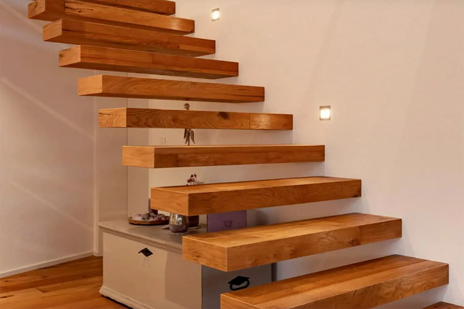 Freitragende Holztreppe mit moderner Beleuchtung – handwerkliche Präzision und zeitloses Design im Innenausbau.