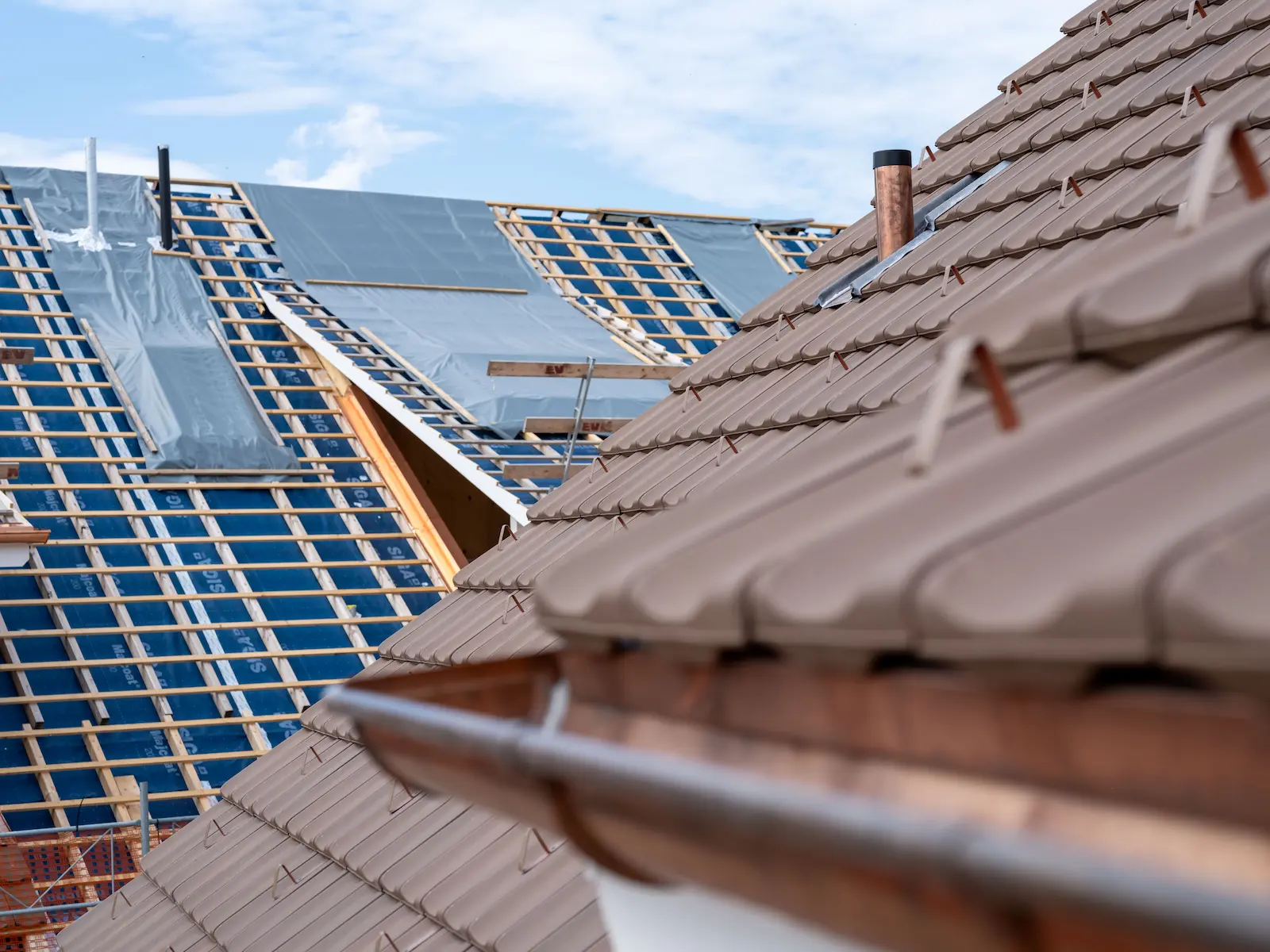 Ziegeldach der Mehrfamilienhäuser Obstgarten in Würenlingen mit verlegten Tonziegeln und vorbereiteten Dachflächen