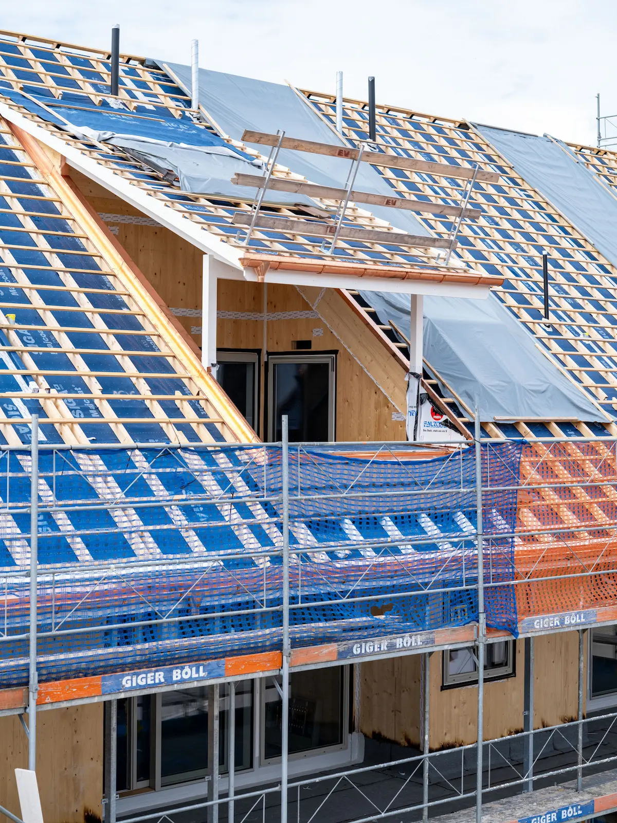 Bedachung der Mehrfamilienhäuser Obstgarten in Würenlingen während der Bauphase mit Dachlattung und Lukarne