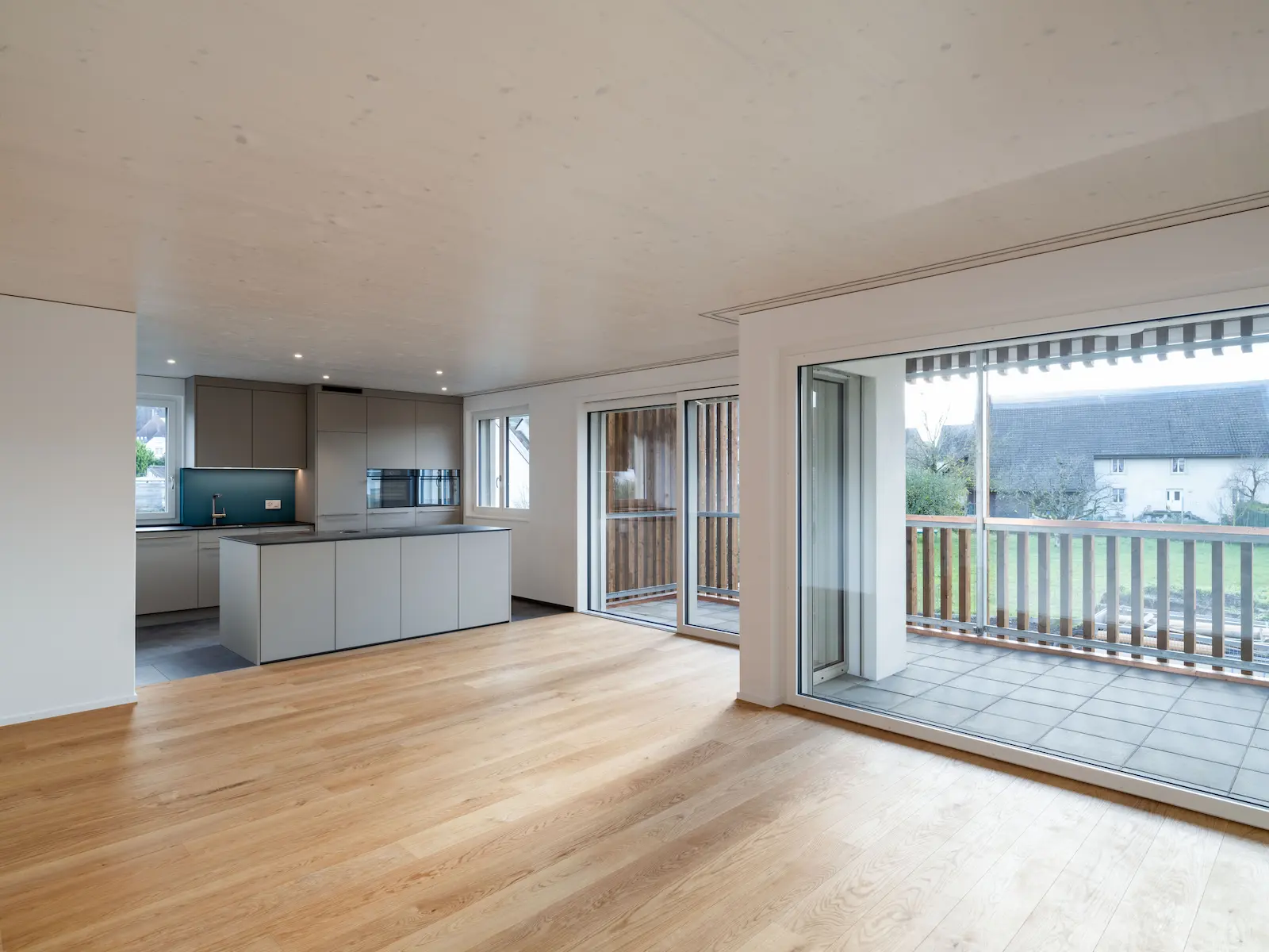 Wohnraum der Mehrfamilienhäuser Obstgarten in Würenlingen mit verlegtem Holzboden und Zugang zur Terrasse