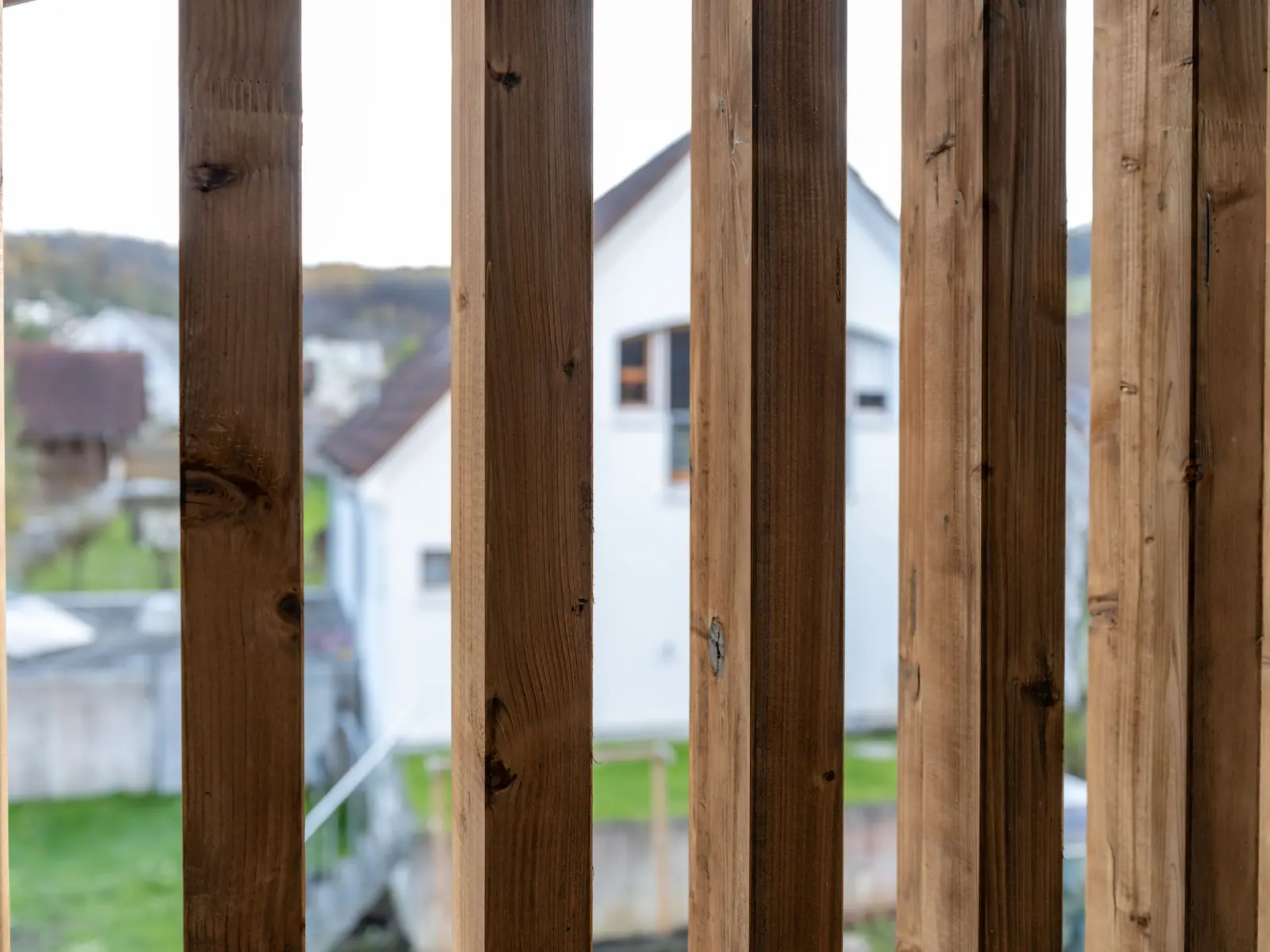 Detail der stehenden Lisenenverkleidung aus Holz an der Balkonfassade in Würenlingen