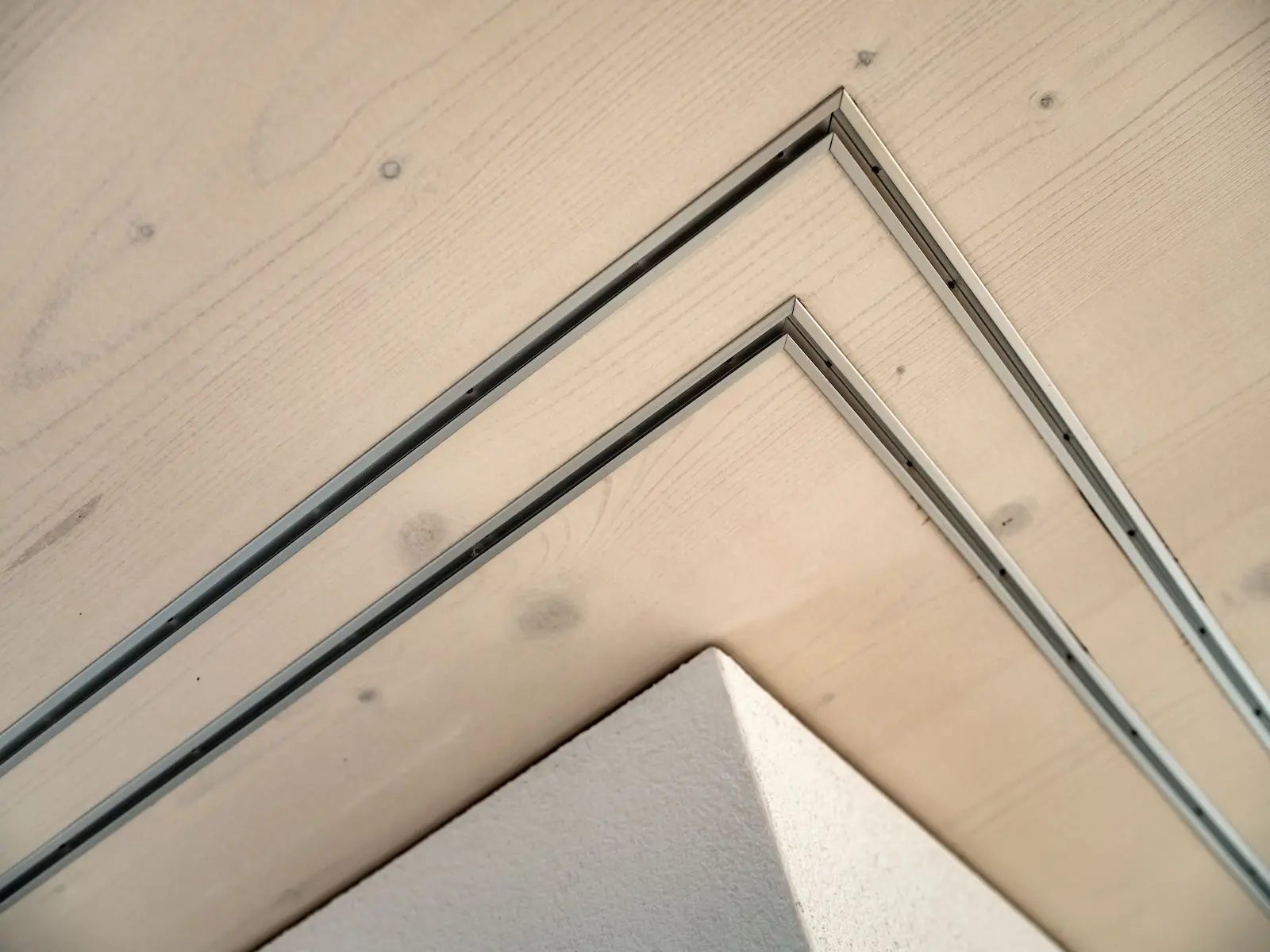 In die Holzdecke eingefräste Vorhangschienen als Teil des präzisen Innenausbaus im Projekt Obstgarten Würenlingen.