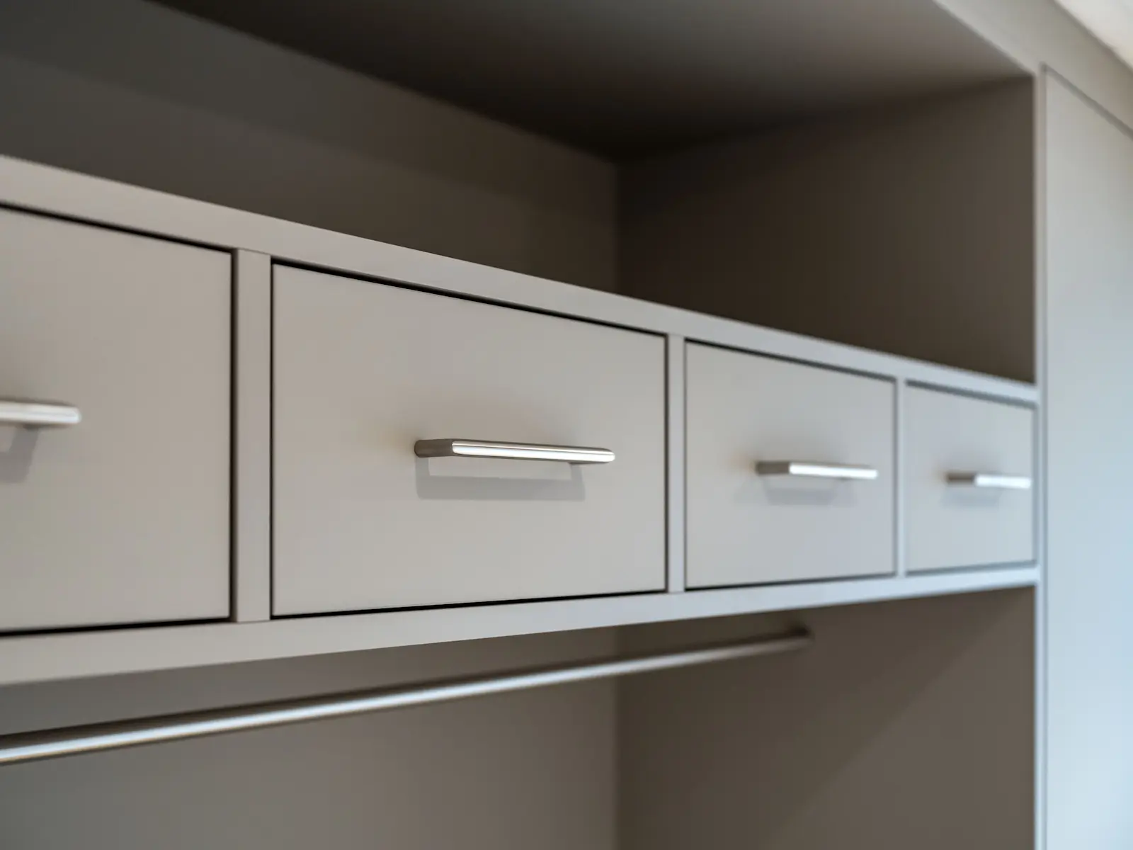 Detailaufnahme der Schubladen einer Einbaugarderobe mit Edelstahlgriffen, gefertigt in der Schreinerei Kleindöttingen
