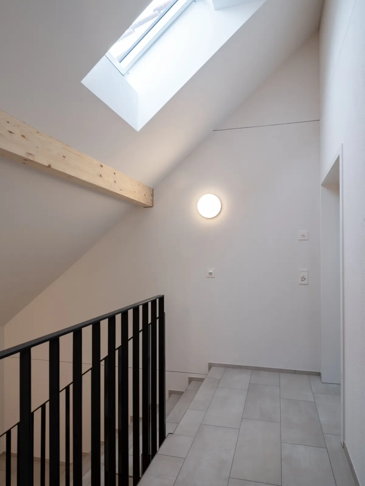 Sichtbare Pfetten und Holzstützen bilden das Tragwerk der Dachwohnung Obstgarten Würenlingen