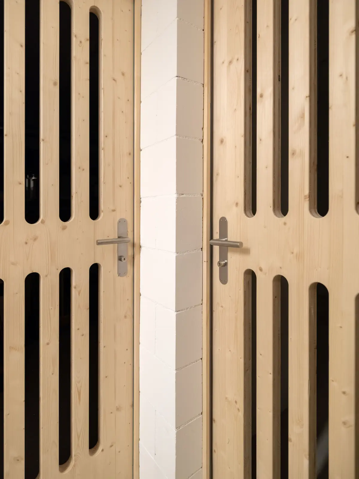 Holztüren aus Dreischichtplatten mit Lüftungsschlitzen in den Kellerabteilen des Mehrfamilienhauses Obstgarten Würenlingen