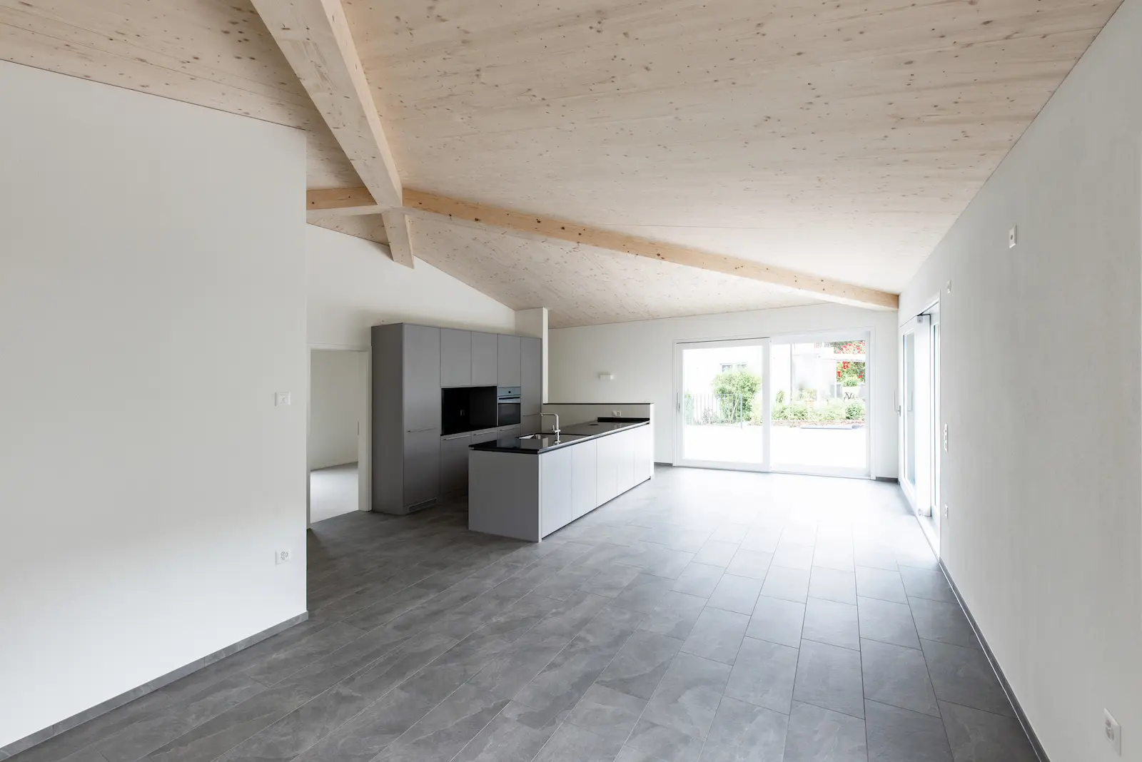 Zentraler Verbindungspunkt der Gratsparren im Zeltdach-Tragwerk aus Brettschichtholz, präzise ausgeführt im modernen Holzbau