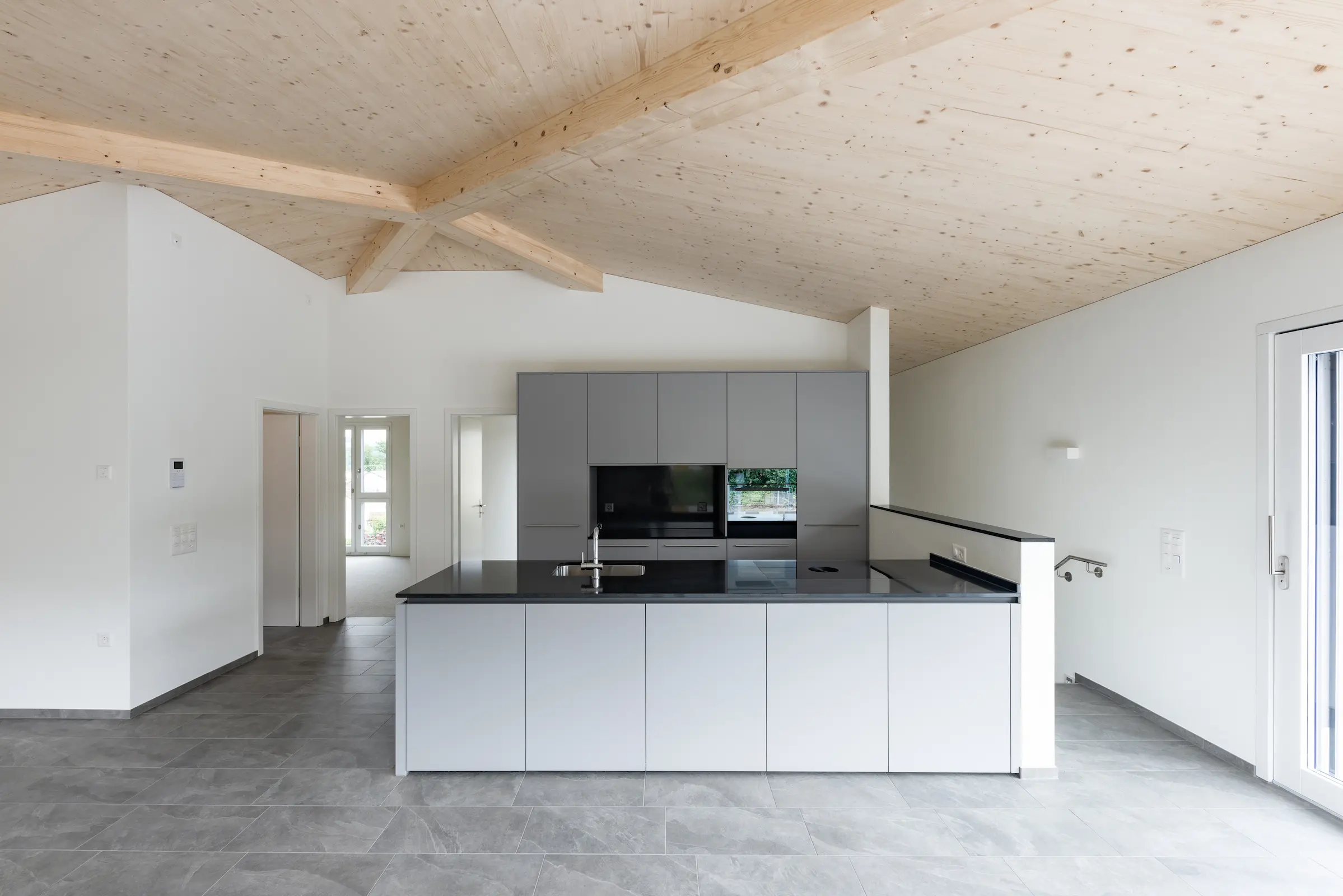 Detailaufnahme der Gratsparren-Verbindung im Zeltdach-Tragwerk aus Brettschichtholz mit sichtbaren Balken und exakter Holzverbindung.