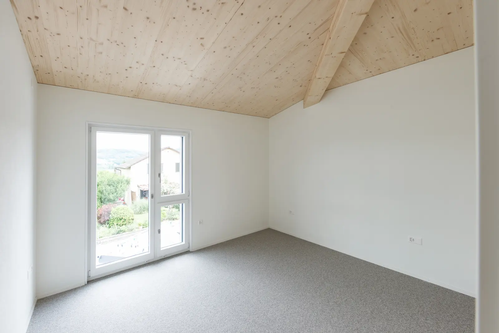 Innenraum mit sichtbaren Dachelementen aus Holz und präziser Verbindung der vorfabrizierten Bauteile.