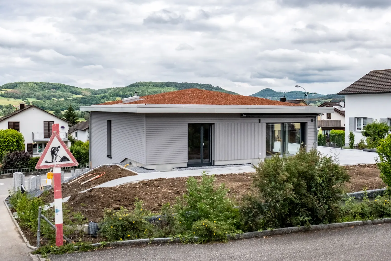 Aktive Dachbegrünung auf flach geneigtem Zeltdach mit präzisen Spenglerabschlüssen und umlaufender Blechverkleidung