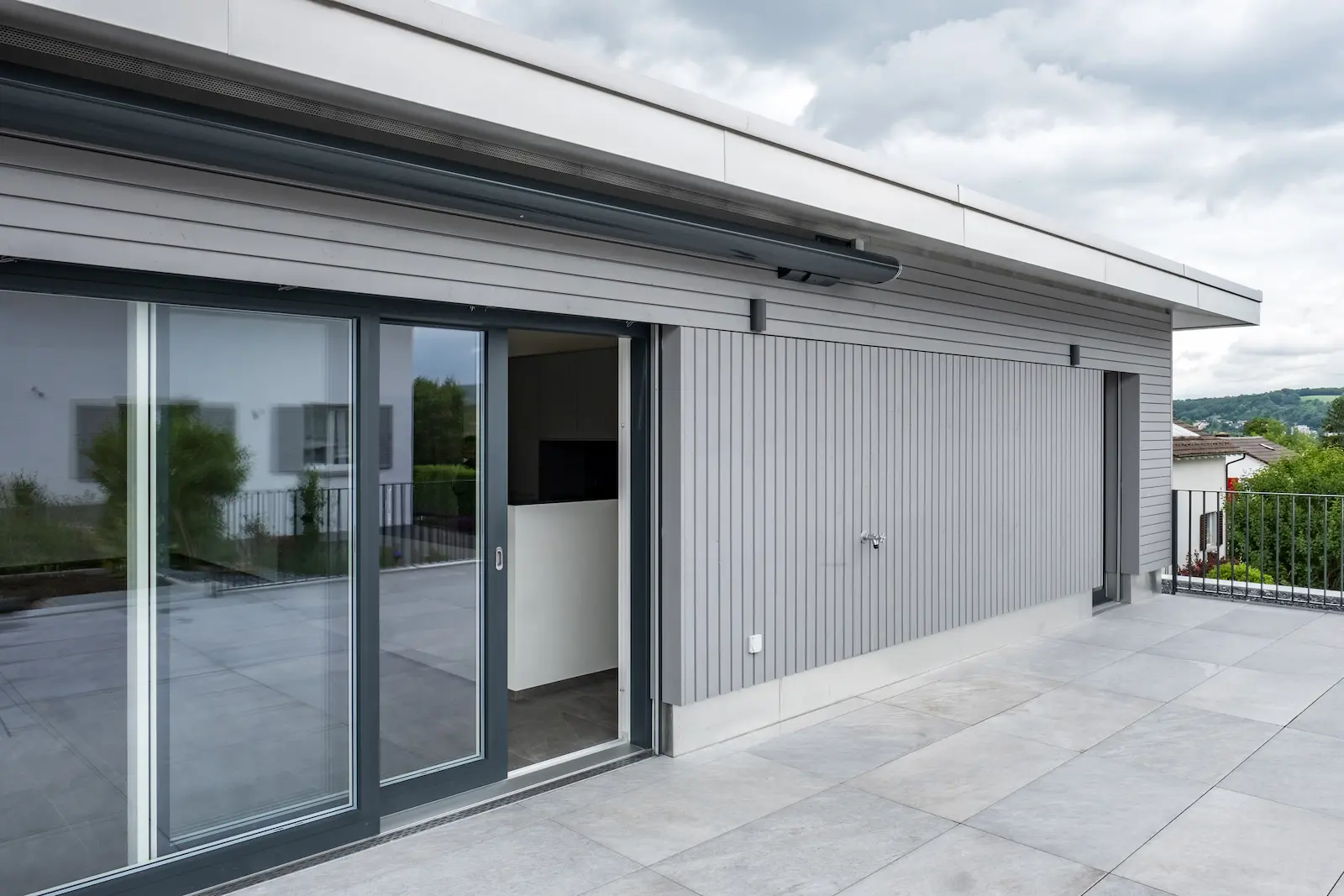 Detail der Spengleranschlüsse mit sauber ausgeführten Sockelblechen und Fassadenabschlüssen in Chromstahl.