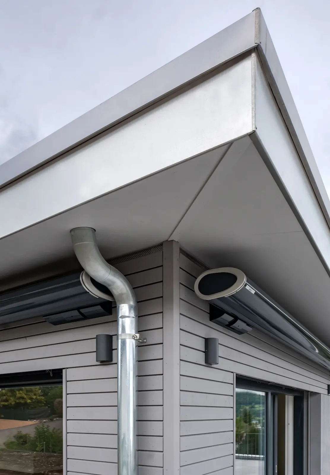 Chromstahl-Fallrohr mit sauber ausgeführter Verkleidung und Anschlussblechen am Zeltdach des Einfamilienhauses in Zurzach.