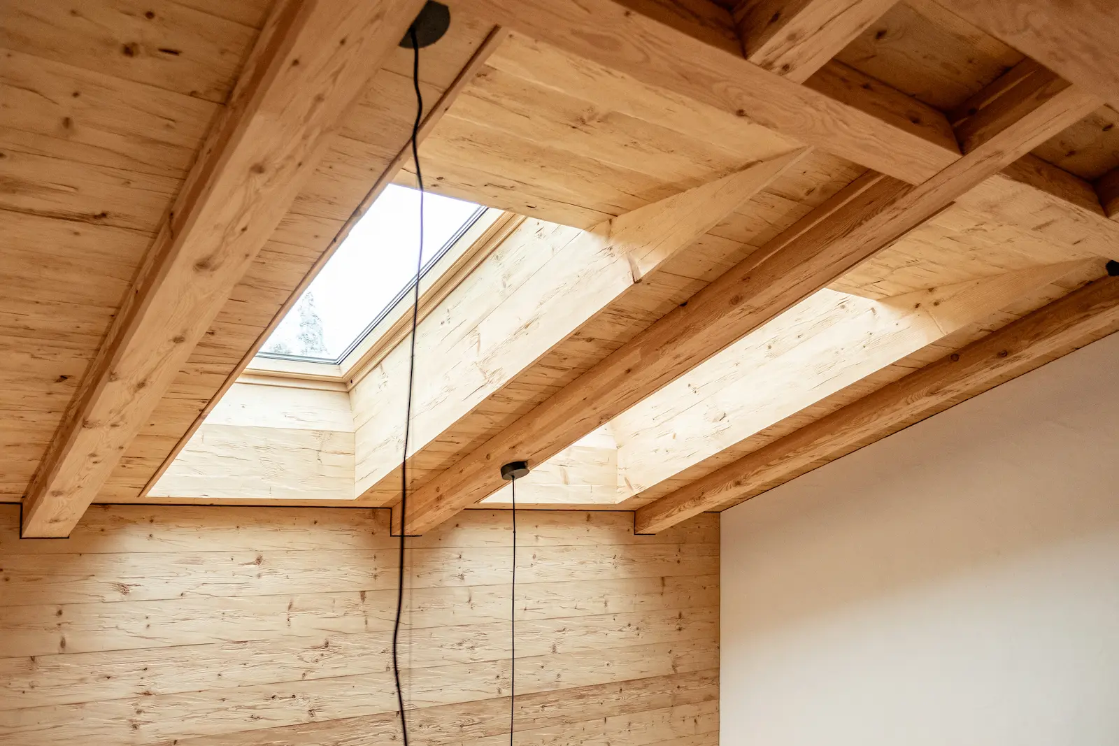 Innenrahmen eines VELUX Dachfensters mit sorgfältig ausgeführtem Dachfensterfutter aus massivem Lärchenholz