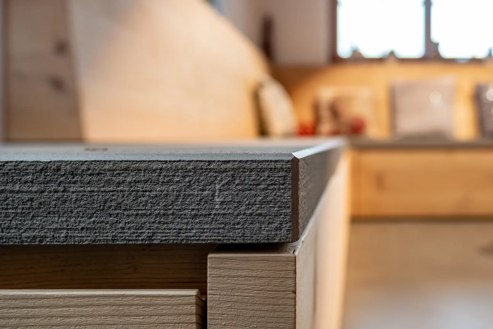 Detail der Einbausitzbank aus Massivholz mit integrierter Steinauflage und präzise gearbeiteten Fugen.