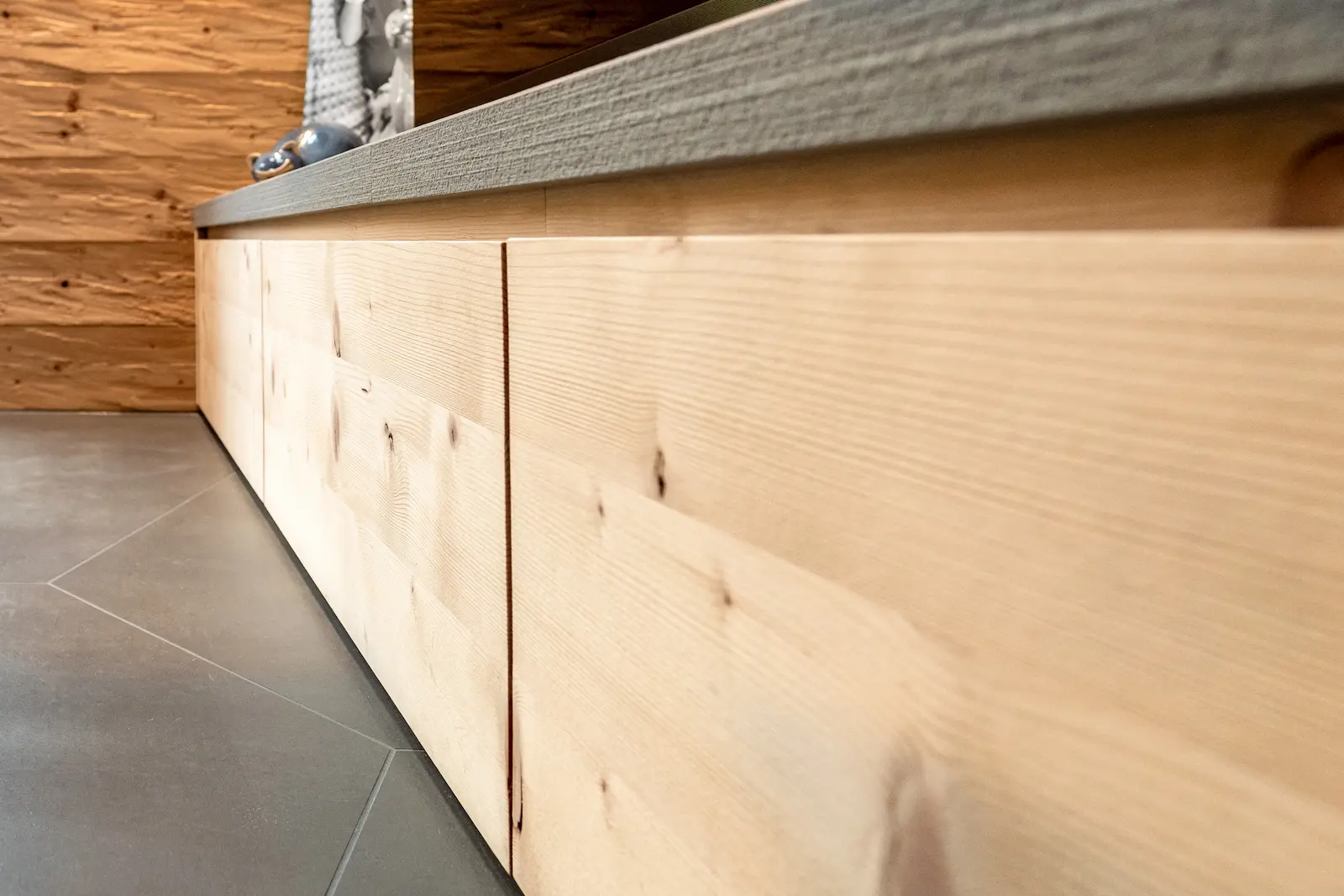 Detailansicht der Sitzbank mit flächenbündigen Schubladen und verdeckten Griffen aus Massivholz.