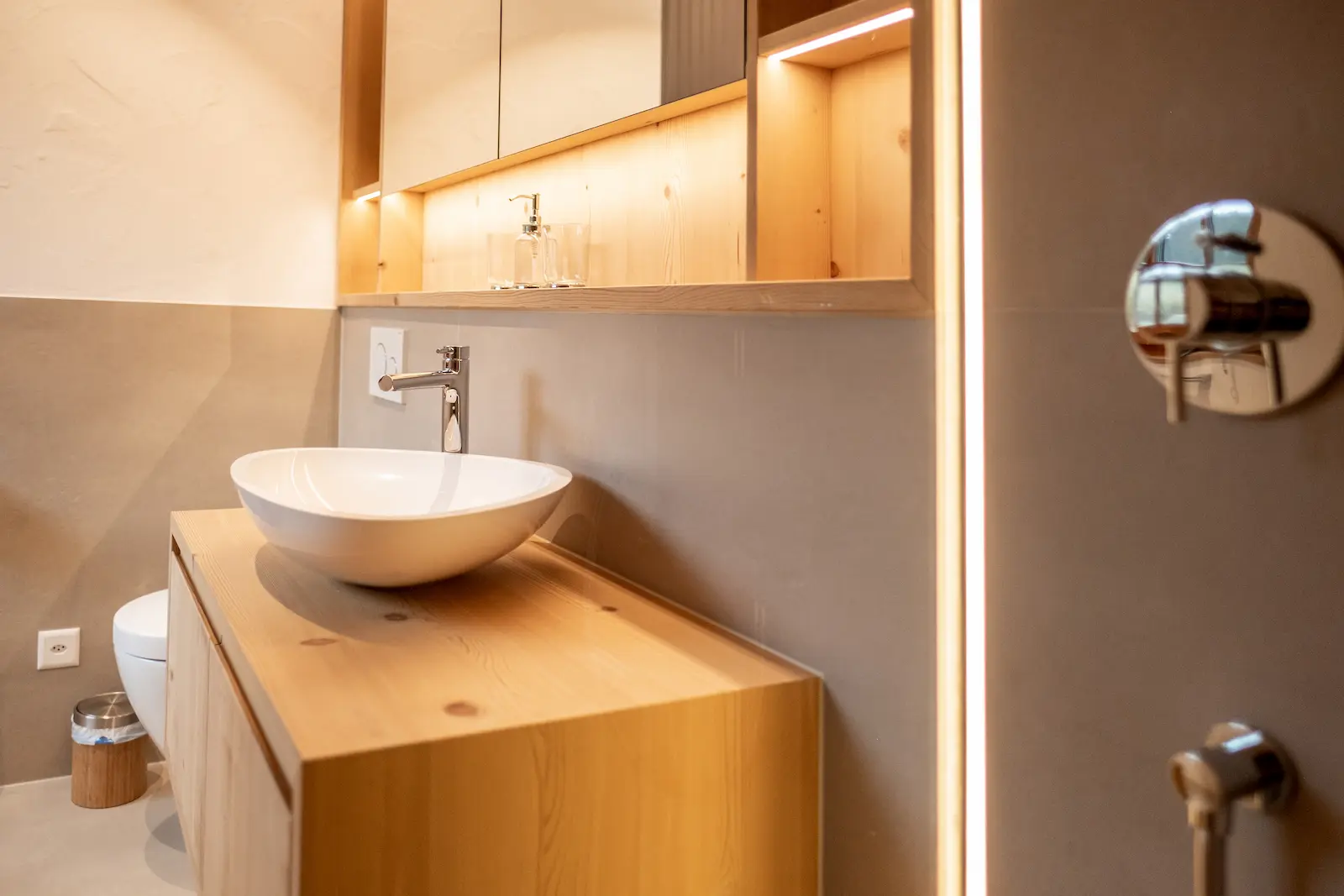 Badmöbel mit Aufsatzwaschbecken, integriertem Spiegelschrank und Massivholzfronten mit LED-Beleuchtung