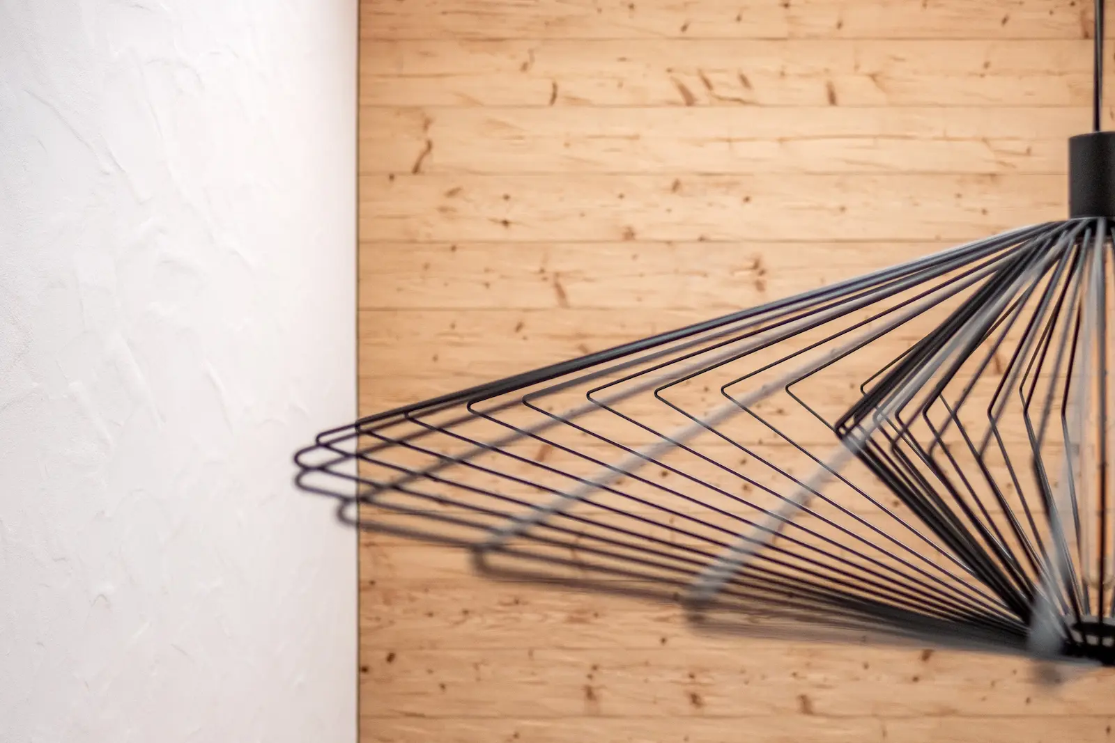 Lärchenwand mit Lichtakzent durch Wandlampe.