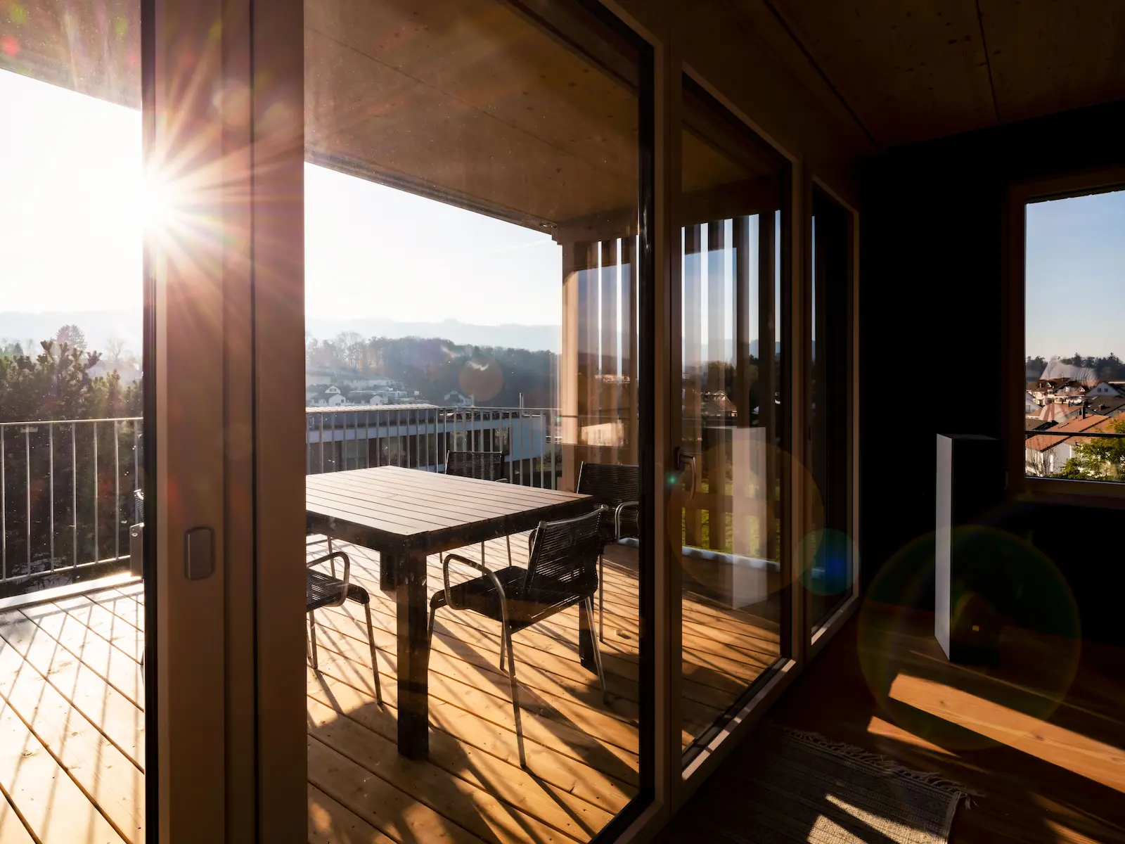 Holzelementbau mit grosser Glasfront eines Mehrfamilienhauses, sichtbar sind die präzise montierten Fensterrahmen und die Holzstruktur der Aussenwände.