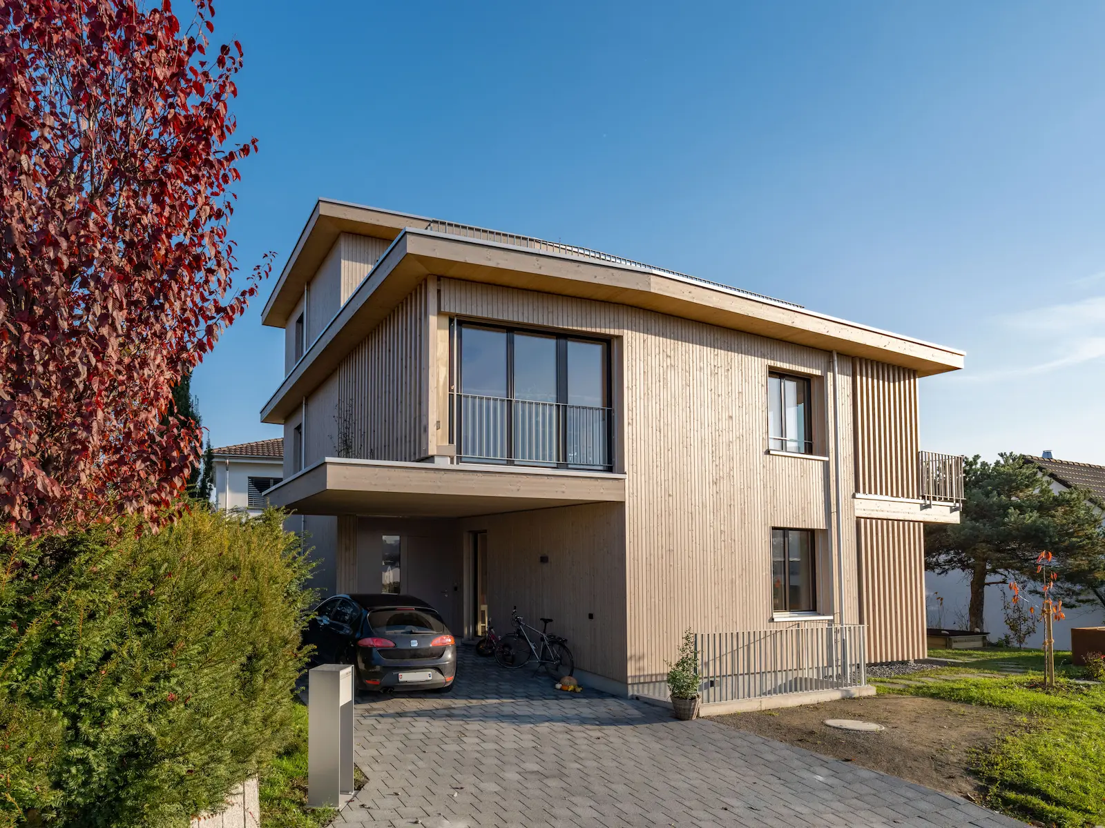 Nahaufnahme der stehenden Holzschalung einer hinterlüfteten Fassade mit leicht grauer Oberflächenbehandlung.