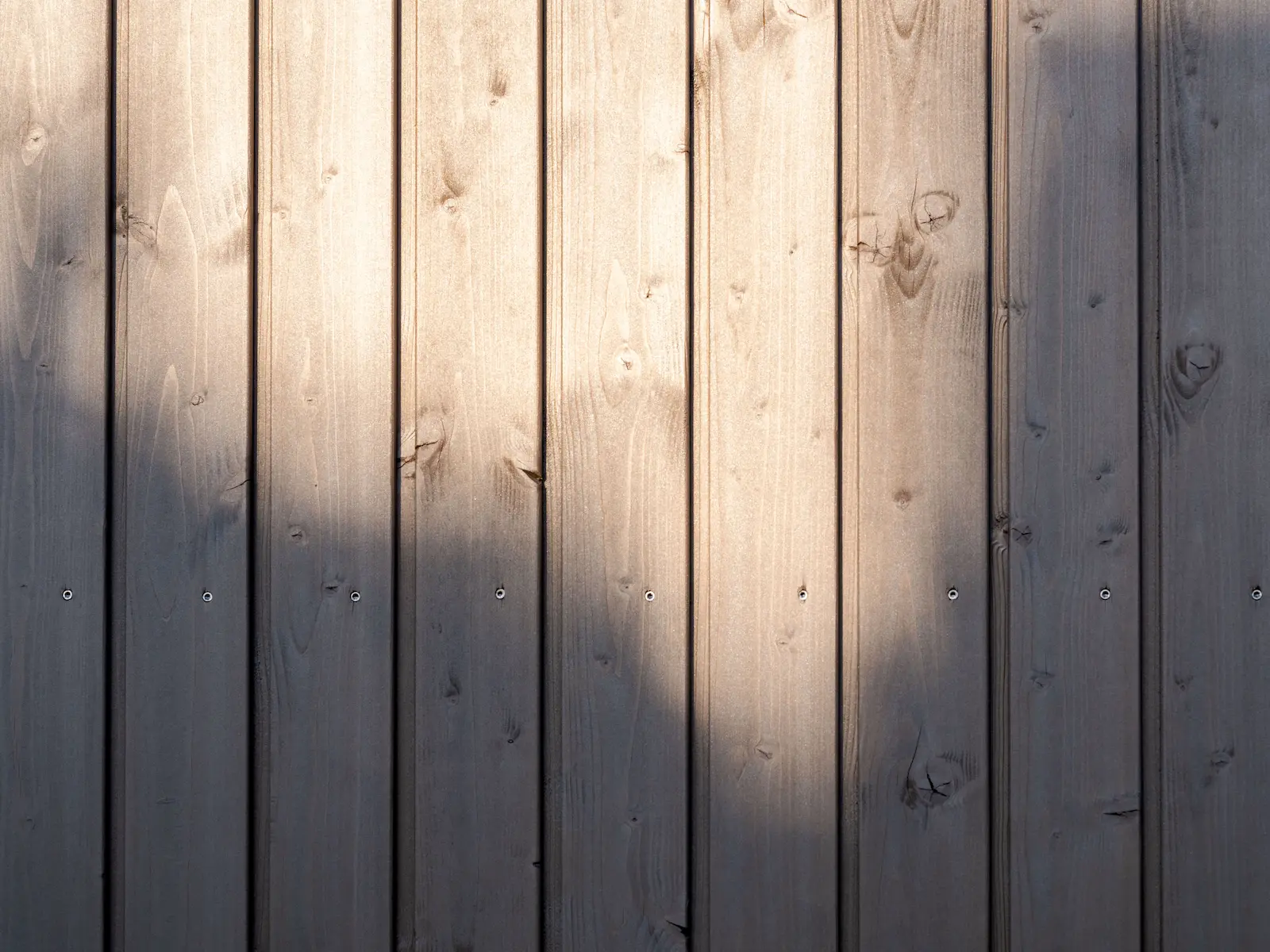 Detailaufnahme der vertikalen Holzschalung aus nordischer Fichte mit sichtbarer Struktur und gleichmässiger Verschraubung.