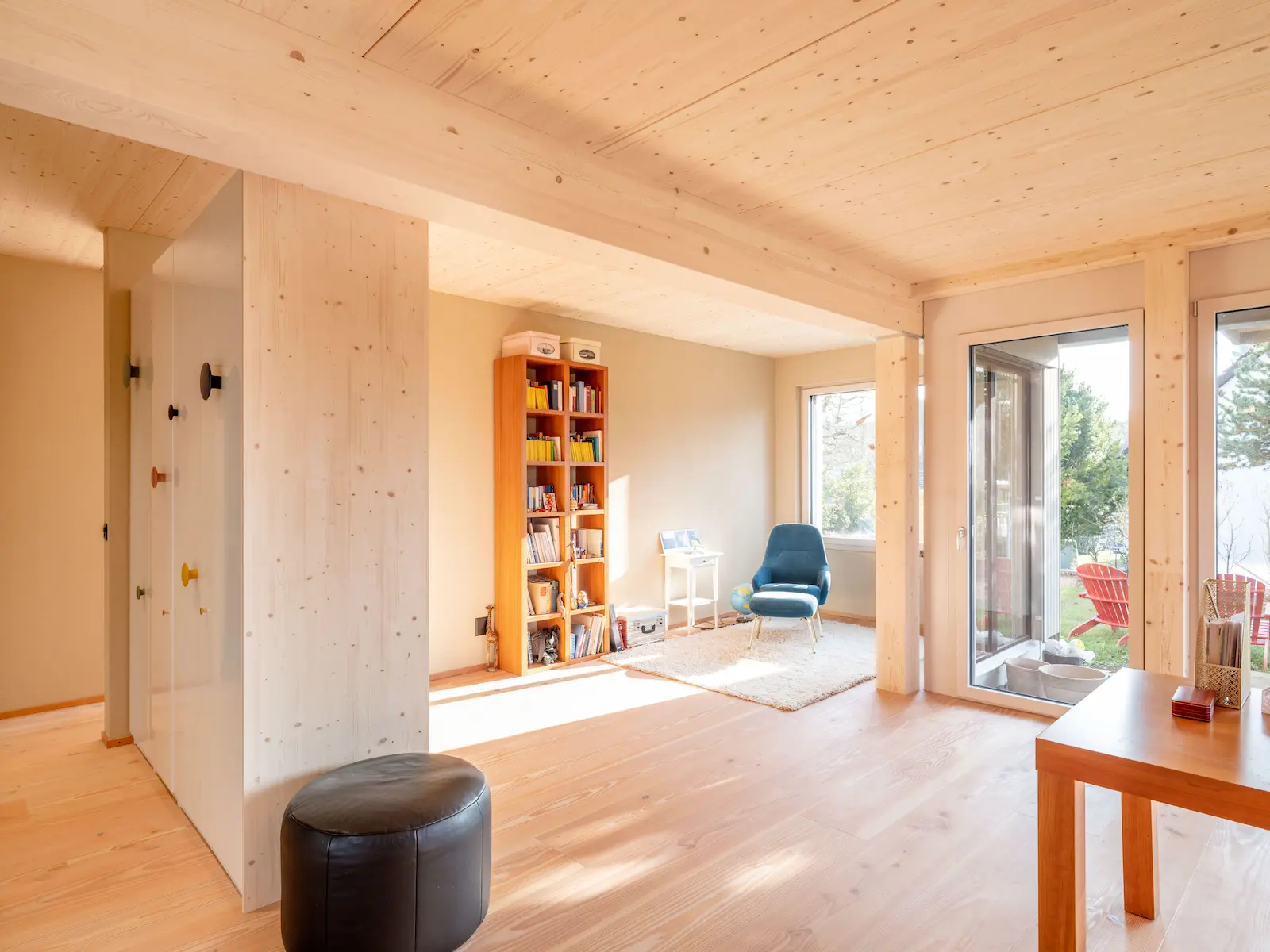 Wohnraum mit sichtbarem Tragwerk aus Brettschichtholz, das als statische Basis für Decke und Wände dient.