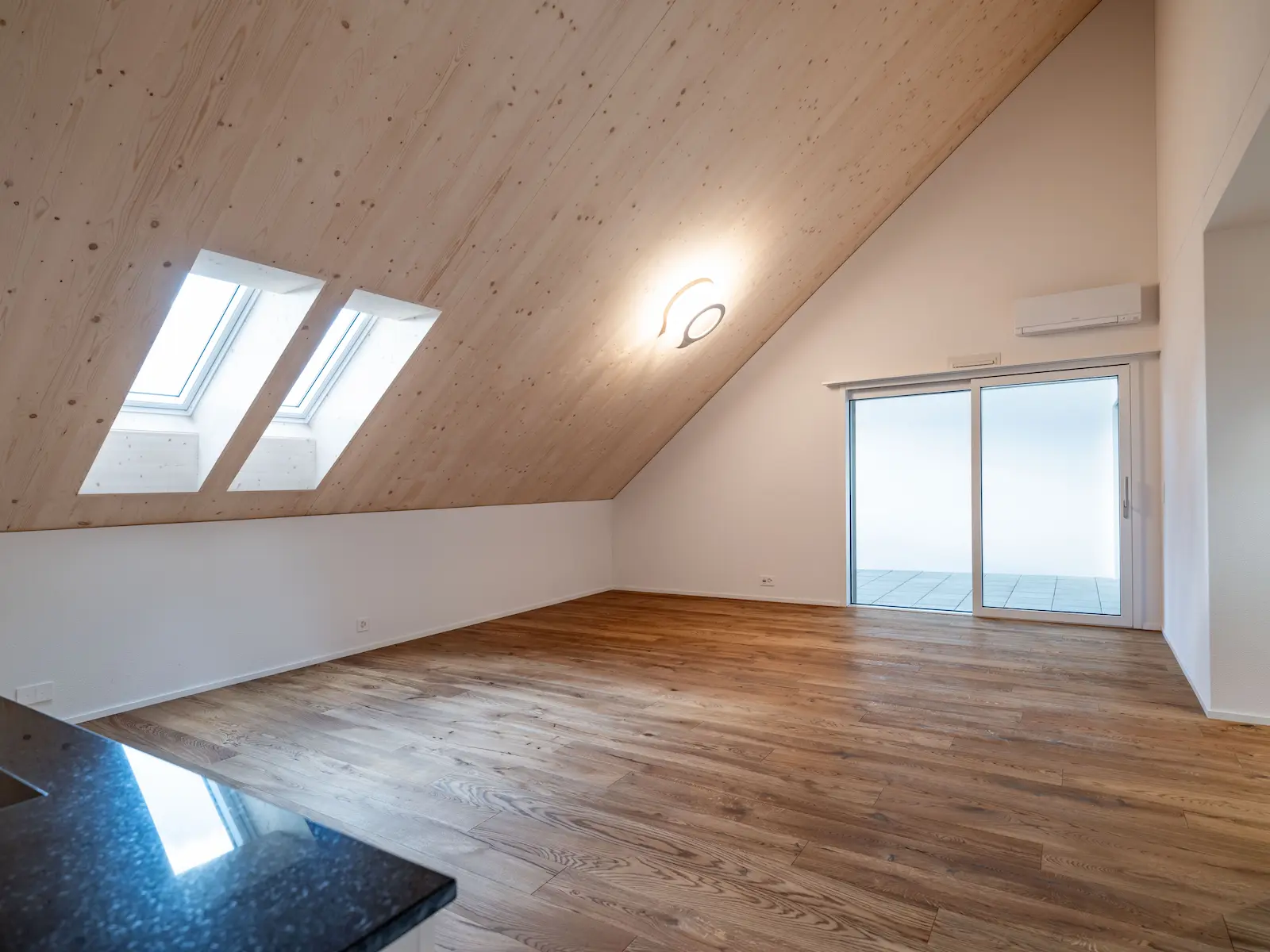 Dachgeschoss der Mehrfamilienhäuser Obstgarten in Würenlingen mit eingebauten VELUX-Dachfenstern in Holzdecke