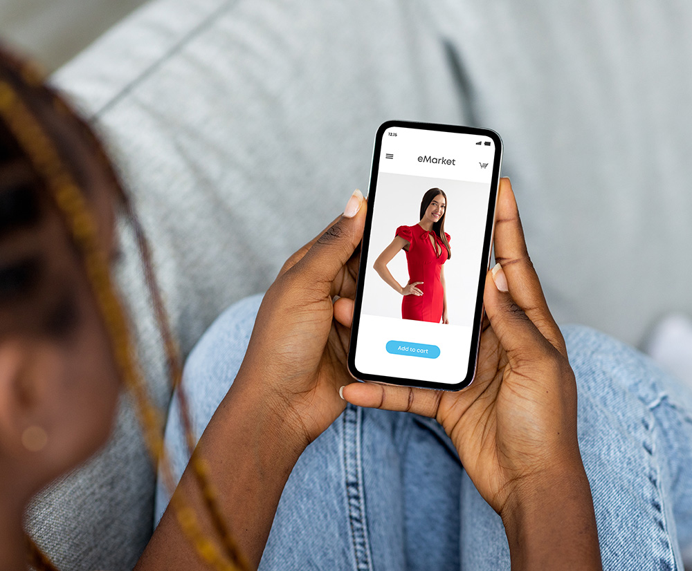 Person holding a phone showing a red dress on a product page