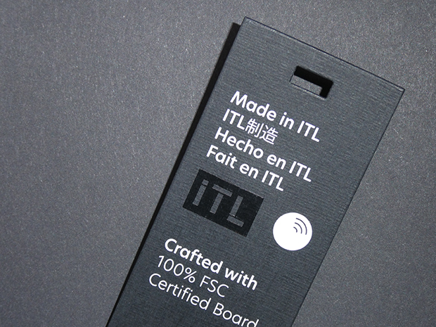 Black swing tag reading "Made in ITL" in four languages, with an NFC icon and "Crafted with 100% FSC certified board"