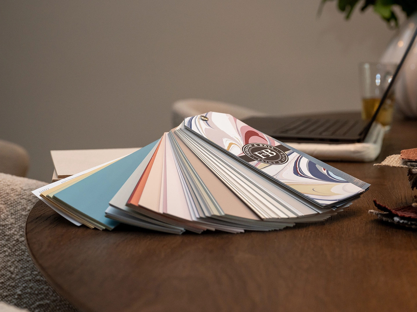 Close-up van kleur- en materiaalstalen op een houten tafel tijdens een interieuradvies door Nouk Interiors.