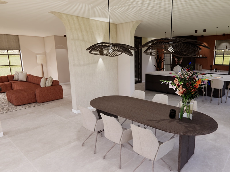 Open leefruimte met ovale donkere eettafel, beige stoelen, bloemenvaas en twee zwarte hanglampen; achterin een moderne keuken en terracotta bank.