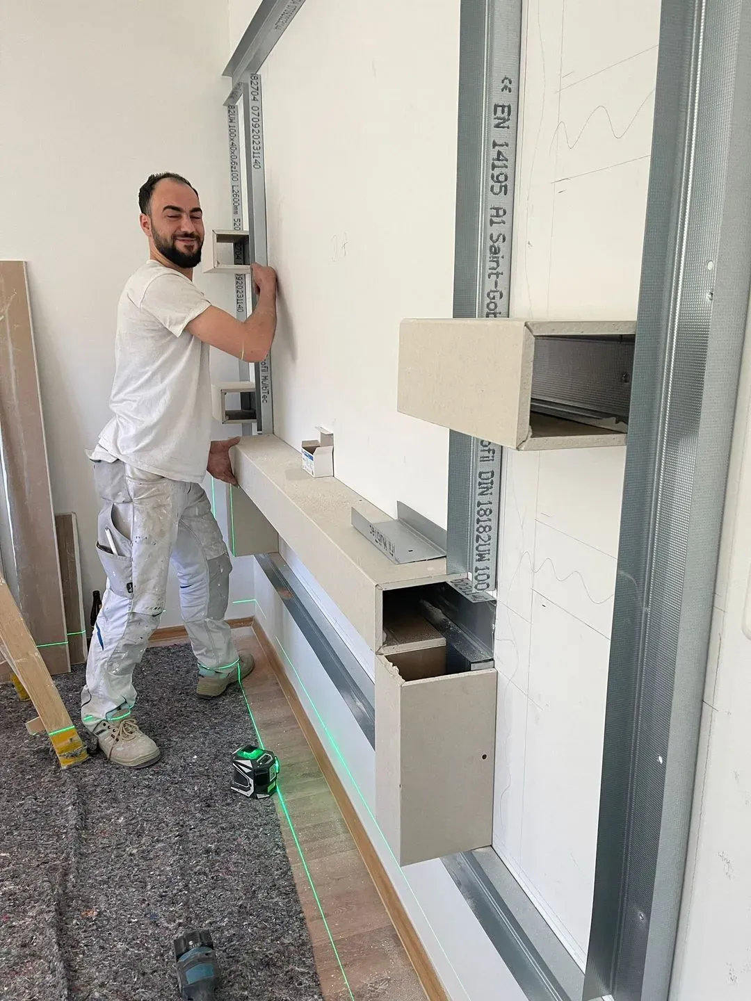 Teammitglied bei der Installation einer Vorsatzschale im Trockenbau.