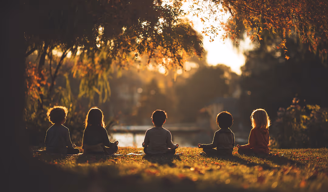 Fünf Kinder sitzen im Schneidersitz im Freien bei Sonnenuntergang und meditieren unter Bäumen.