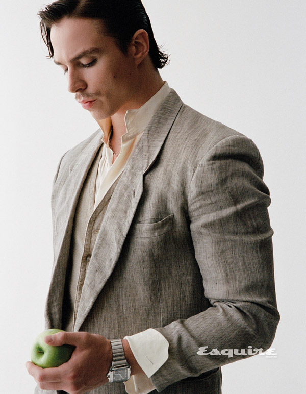 Nicholas Alexander Chavez in tailored suit holding an apple