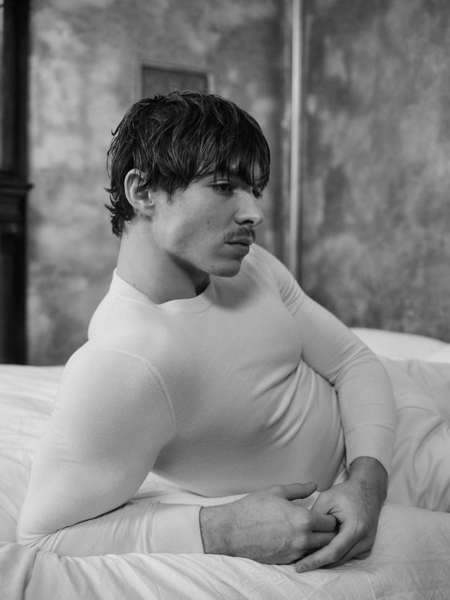 Nicholas Alexander Chavez reclining in white knit