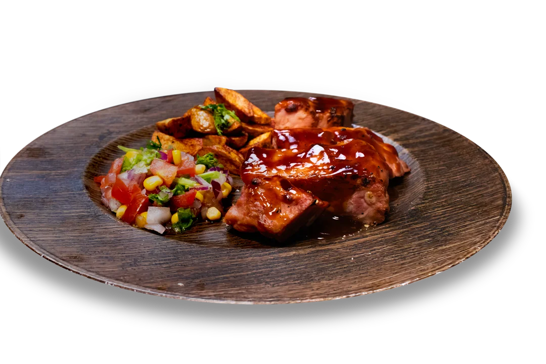 costillas de cerdo bañadas en salsa BBQ acompañadas de papas fritas y ensalada