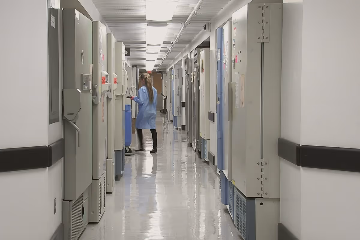 A nurse wearing blue scrubs walking down a hospital corridor