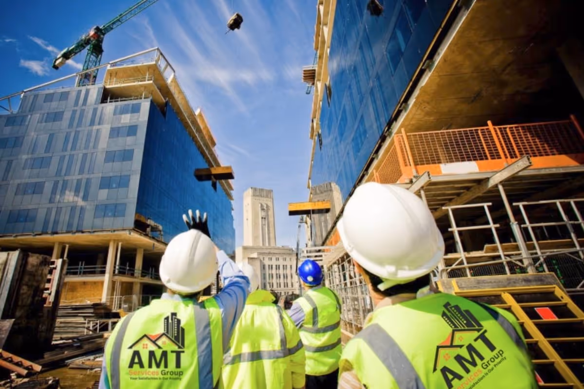 AMT Service workers inspecting building site with crane and scaffolding equipment on premises.