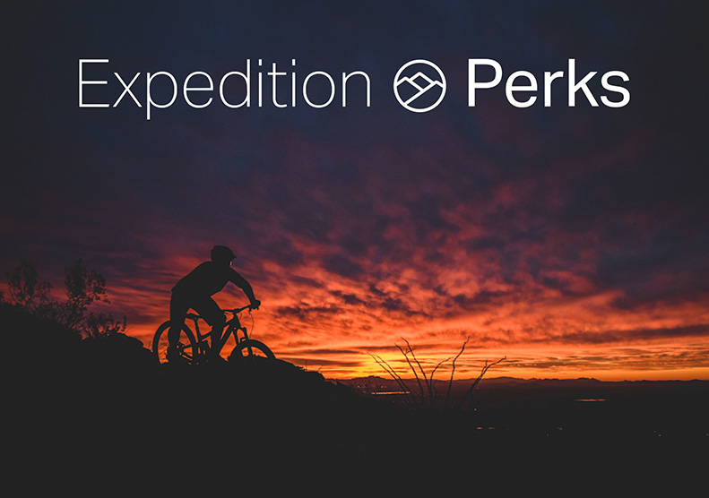 Expedition Perks white logo over a mountain biker at sunset. Photographer: Re Wikstrom