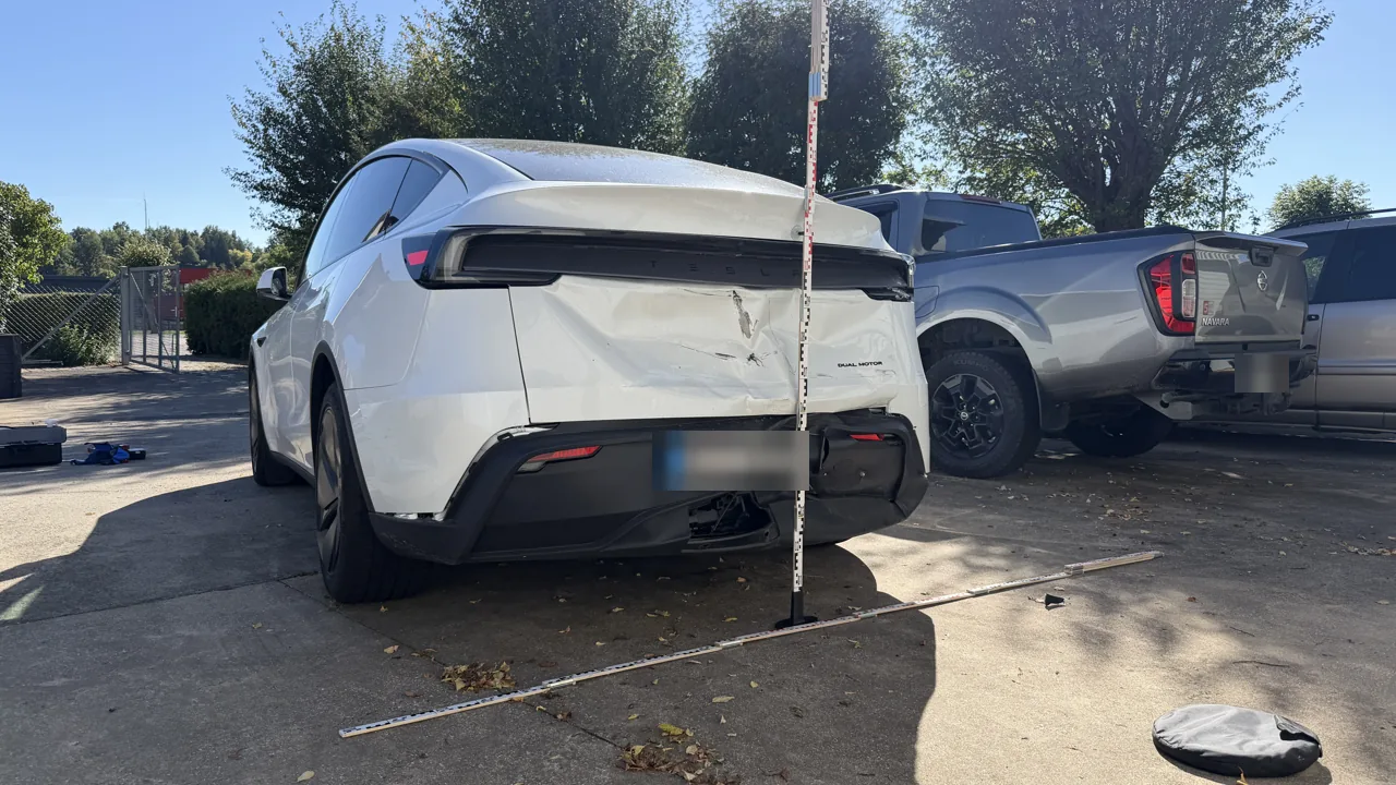 Tesla Model Y mit Heckschaden nach Auffahrunfall, Anstoßhöhe für das Tesla-Gutachten mit Messlatte dokumentiert