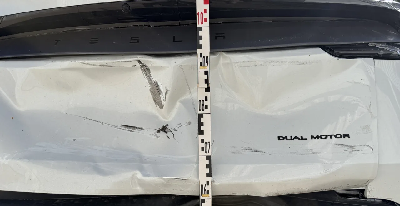 Eingedrückte Heckklappe eines Tesla Model Y mit Messlatte, Kontaktspuren des auffahrenden Fahrzeugs