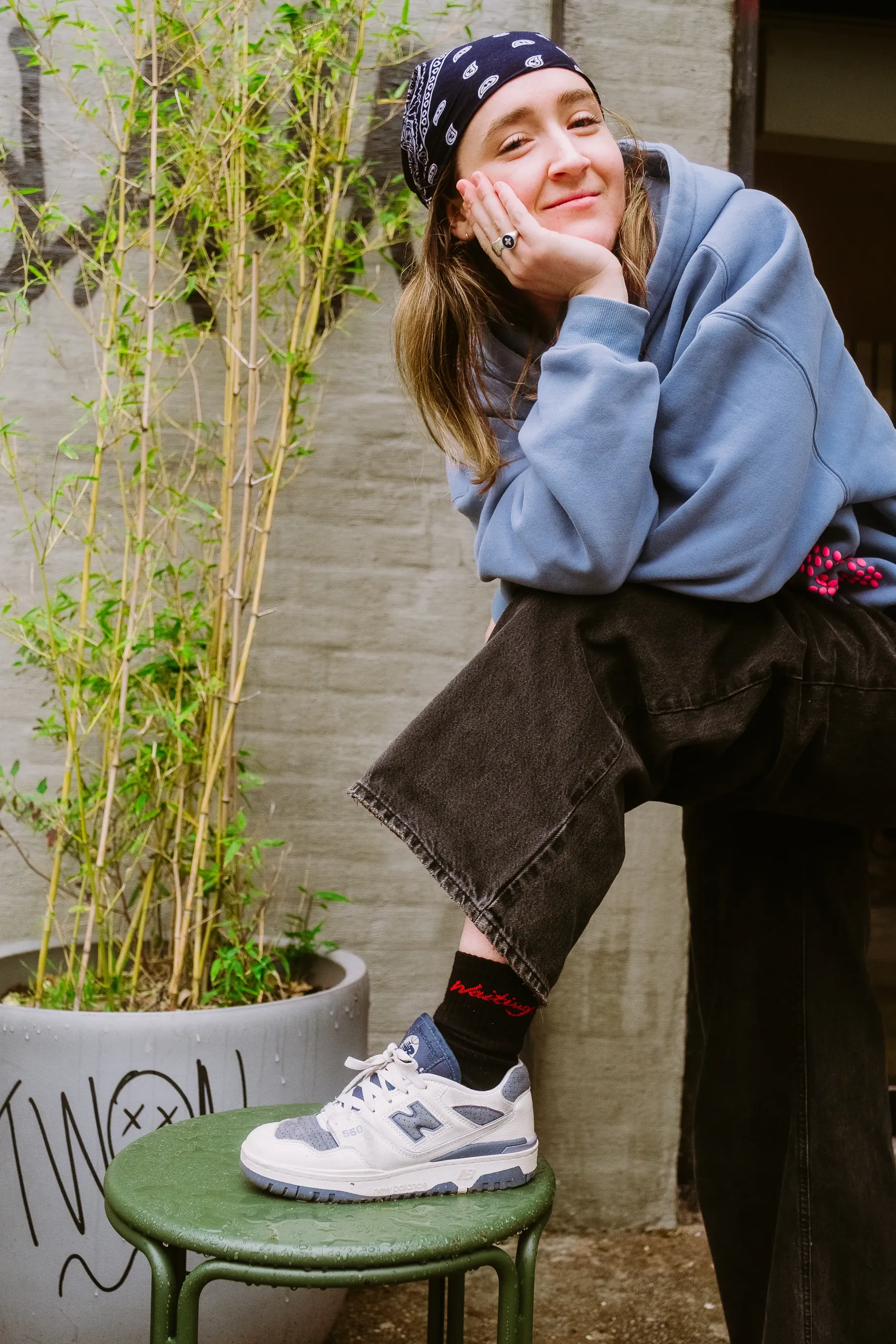 A reader in a bandana and blue sweatshirt wearing Waiting socks