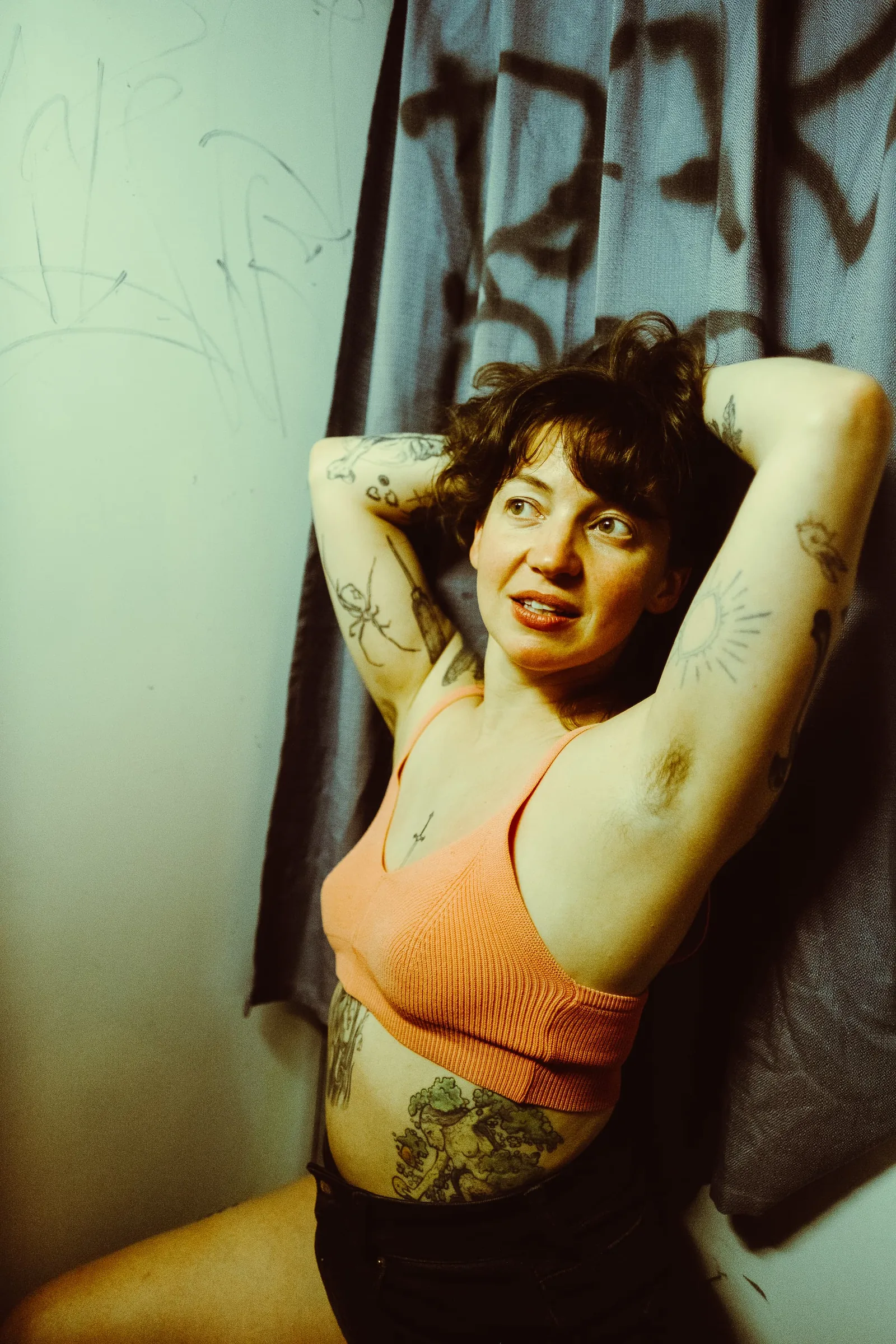 Painter Kate Alboreo against a hanging canvas