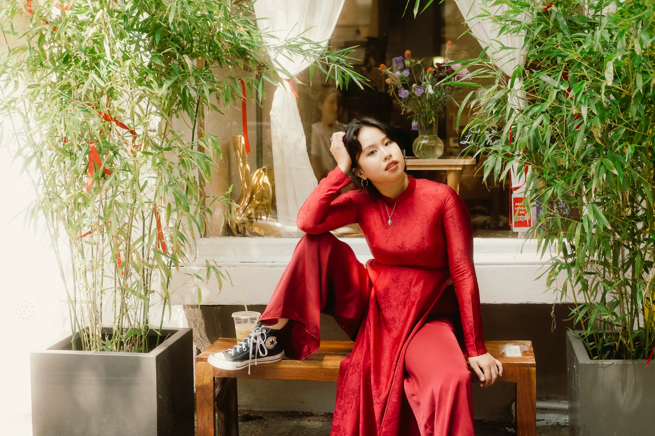Trà My Truong in a red dress among green plants
