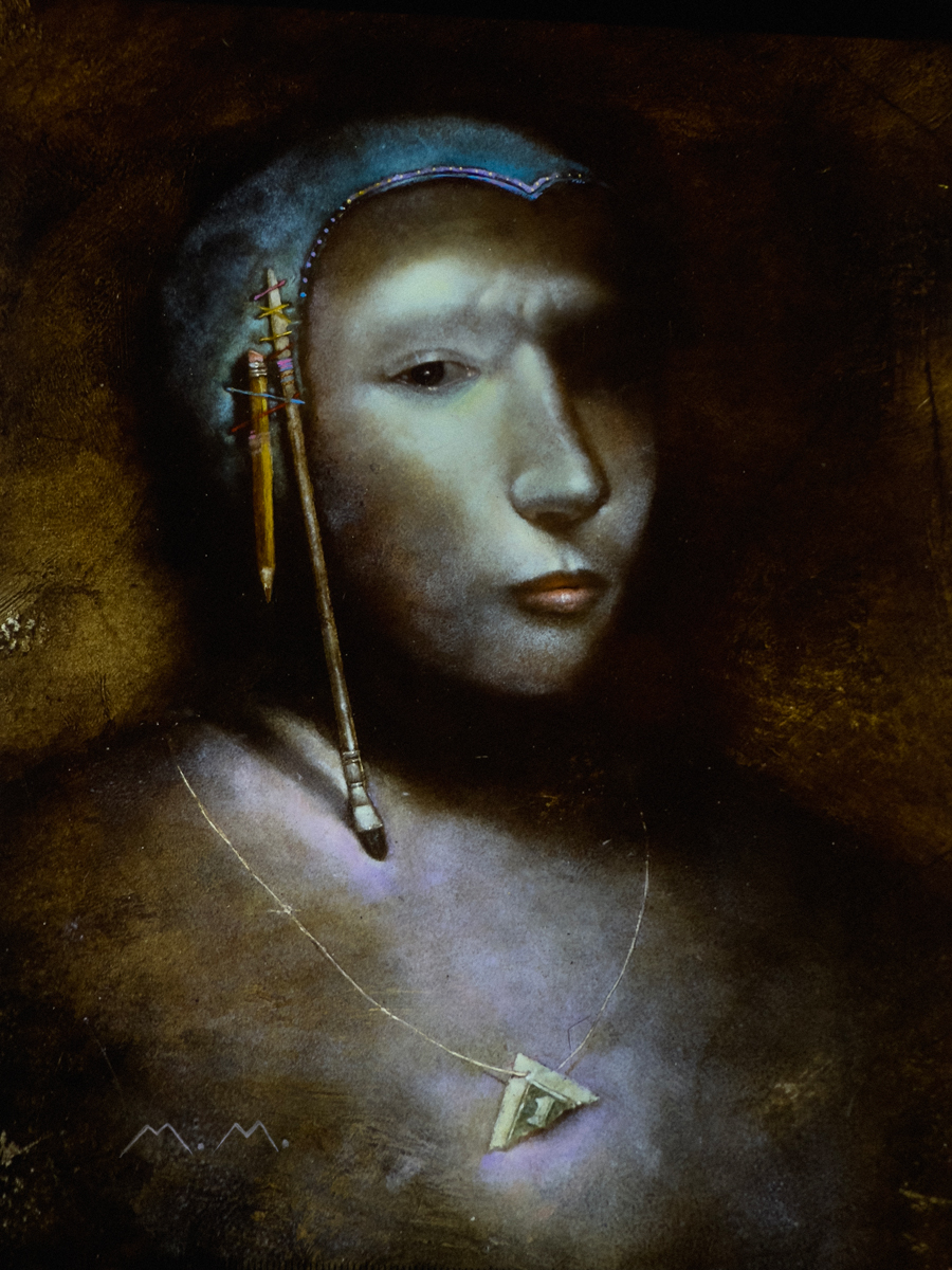 Surreal portrait of a face with a pencil and paintbrush hanging from the head and a necklace with a triangular pendant.