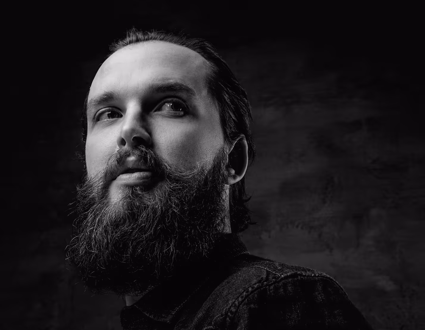 Black and white image of a bearded man looking in the distance