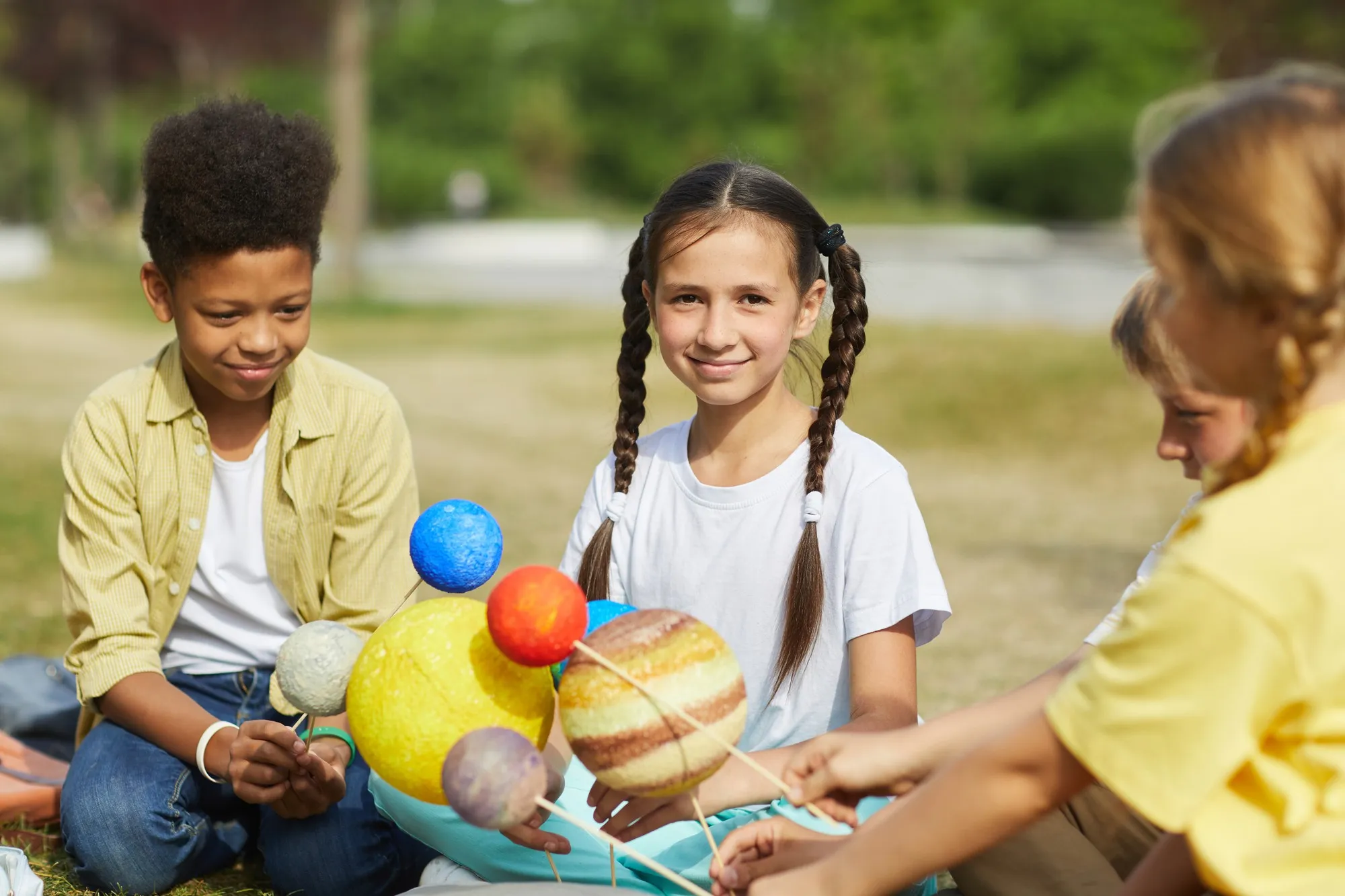 A group of children sitting on the ground together.