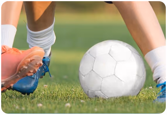A foot of a person near the white soccer ball