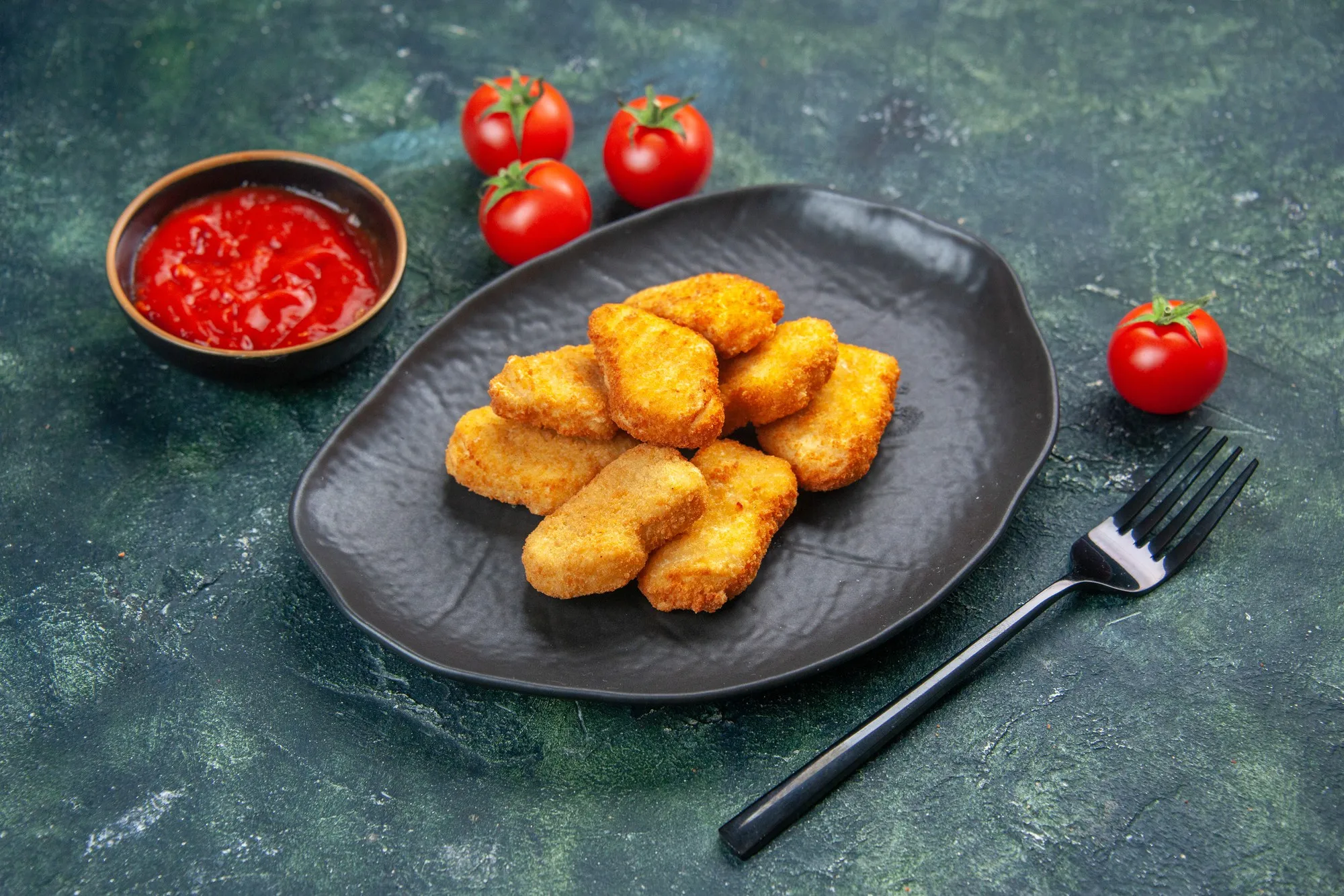 Chicken nuggets served with ketchup.